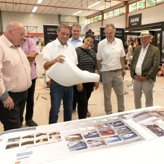 Geschäftsführer Martin Schütz (rechts) erläutert Ulrich Theis, Bürgermeister Andreas Heidrich, Bürgermeister Gerrit Müller, Katharina Schlag, Landrat Achim Schwickert, Ortsbürgermeister Jochen Becker und Karsten Lucke, MdEP (von rechts) die Produktpalette des Betten-fachgeschäfts Modehaus Schütz.