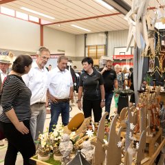 Geschäftsführerin Nicole Sahm (rechts) erläuterte Ortsbürgermeister Jochen Becker (hinten links), Katharina Schlag, Bürgermeister Andreas Heidrich und Landrat Achim Schwickert (vorne von links) das neue Angebot des Holzstudios Sahm, was auch Gesprächsthema von Karsten Lucke, MdEP (hinten 2.v.l.) und Ulrich Theis (hinten rechts) war.