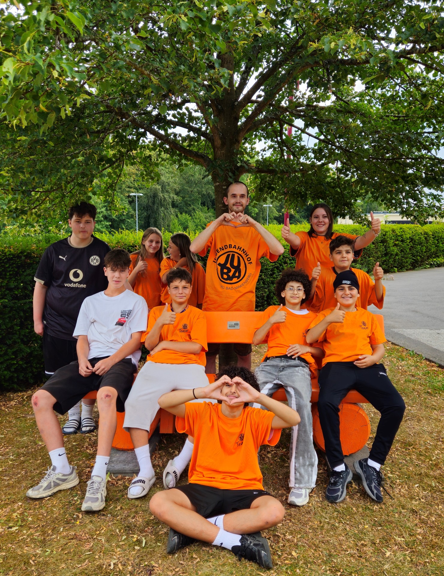 Teilnehmer in orangen T-Shirts.