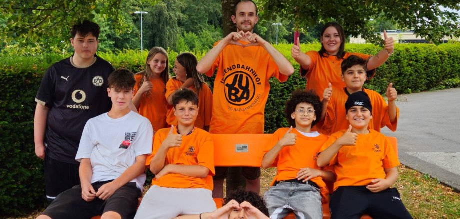 Teilnehmer in orangen T-Shirts.