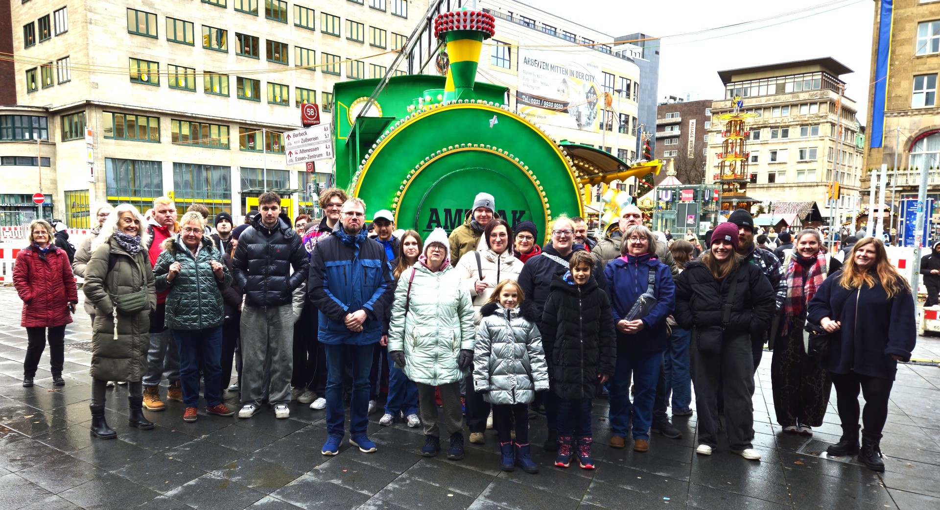 Jugendliche, Familien und Senioren hatten trotz grauem Regenwetter gleichermaßen Spaß beim ganztägigen gemeinsamen Entdecken der vielfältigen internationalen Angebote des Essener Weihnachtsmarktes und seiner besonderen Atmosphäre, hier vor einer Süßigkeiten-Lok am Eingang des Weihnachtsmarktes Jugendliche, Familien und Senioren hatten trotz grauem Regenwetter gleichermaßen Spaß beim ganztägigen gemeinsamen Entdecken der vielfältigen internationalen Angebote des Essener Weihnachtsmarktes und seiner besonderen Atmosphäre, hier vor einer Süßigkeiten-Lok am Eingang des Weihnachtsmarktes