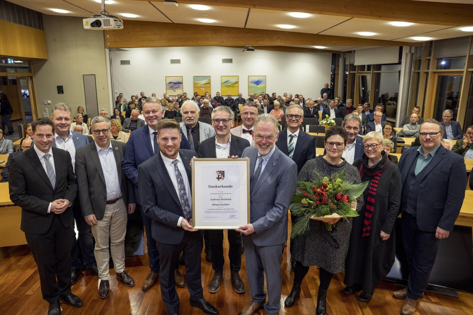 Andreas Heidrich empfängt die Dankurkunde im Rahmen der Ratssitzung.