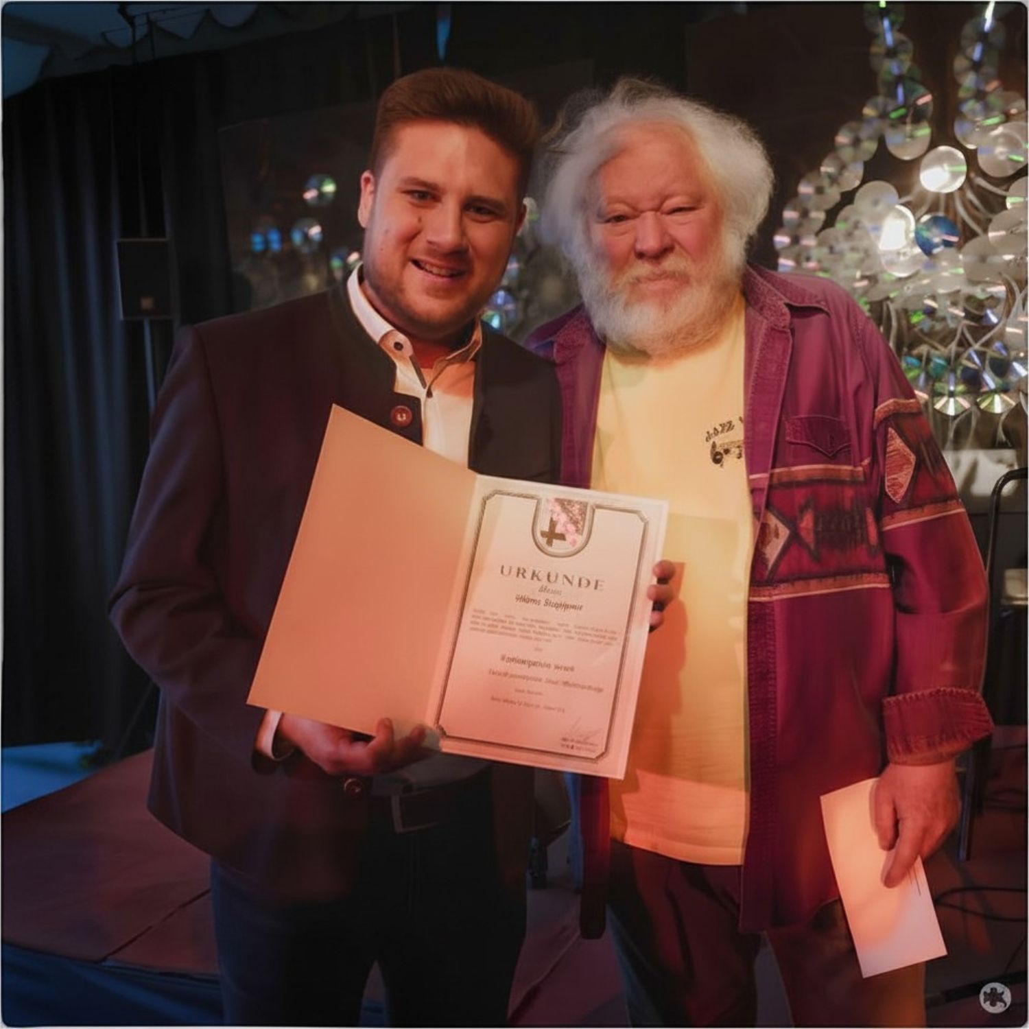 Im Rahmen des Konzerts von Matthias „Biber“ Herrmann als Teil der Reihe „Jazz we can“ in der Praxis für Ergotherapie in Bad Marienberg überreichte Bürgermeister Mar-vin Kraus (links) unter großem Applaus des Publikums den Kulturpreis der Verbands-gemeinde Bad Marienberg an Hans Ruppert.
