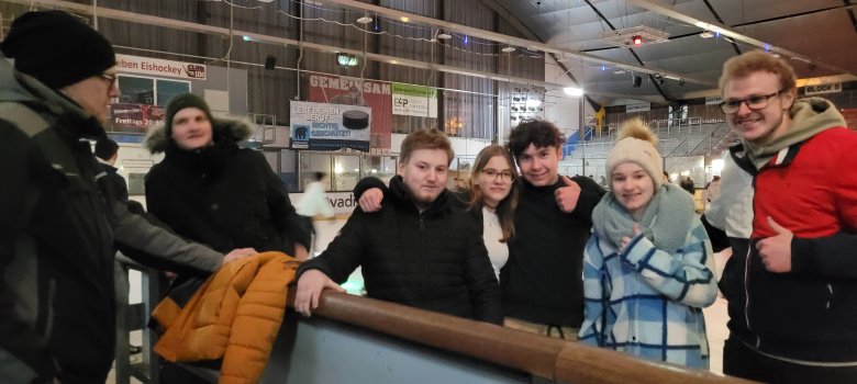Einige Teilnehmende der Gruppe mit Dauen hoch für die Fun-Night der Eissporthalle Diez