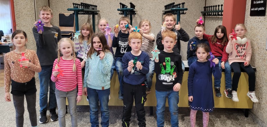 Kinder präsentieren ihre gebastelten Hasen.