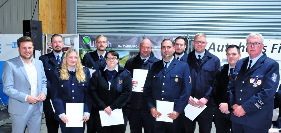 Gemeinsam mit Wehrleiter Frank Schiffmann und dessen Stellvertreter Tobias Schüler (v.r.) freute sich der Erste Beigeordnete Marvin Kraus (links) über das seltene 100-jährige Jubiläum der Freiwilligen Feuerwehr Hof. Im Rahmen der Veranstaltung nahm Kraus einige Ernennungen und Beförderungen der Hofer Wehrleute vor. Hintere Reihe: Pascal Schäfer (Oberfeuerwehrmann), Tim Robin Künkler (Oberfeuerwehrmann), der neu ernannte Wehrführer Christoph Renner sowie Theo Renner (Hauptfeuerwehrmann). Vordere Reihe: Clara Renner (Oberfeuerwehrfrau), Lena Weller (Verpflichtung), der frühere Wehrführer Dominic Jung und der neue stellvertretende Wehrführer Niclas Künkler. Gemeinsam mit Wehrleiter Frank Schiffmann und dessen Stellvertreter Tobias Schüler (v.r.) freute sich der Erste Beigeordnete Marvin Kraus (links) über das seltene 100-jährige Jubiläum der Freiwilligen Feuerwehr Hof. Im Rahmen der Veranstaltung nahm Kraus einige Ernennungen und Beförderungen der Hofer Wehrleute vor. Hintere Reihe: Pascal Schäfer (Oberfeuerwehrmann), Tim Robin Künkler (Oberfeuerwehrmann), der neu ernannte Wehrführer Christoph Renner sowie Theo Renner (Hauptfeuerwehrmann). Vordere Reihe: Clara Renner (Oberfeuerwehrfrau), Lena Weller (Verpflichtung), der frühere Wehrführer Dominic Jung und der neue stellvertretende Wehrführer Niclas Künkler.