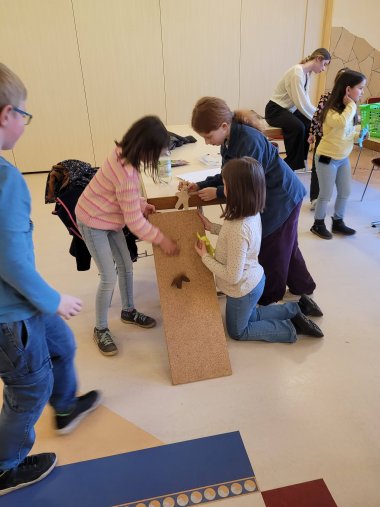 Kinder spielen mit ihren gebastelten Hasen.