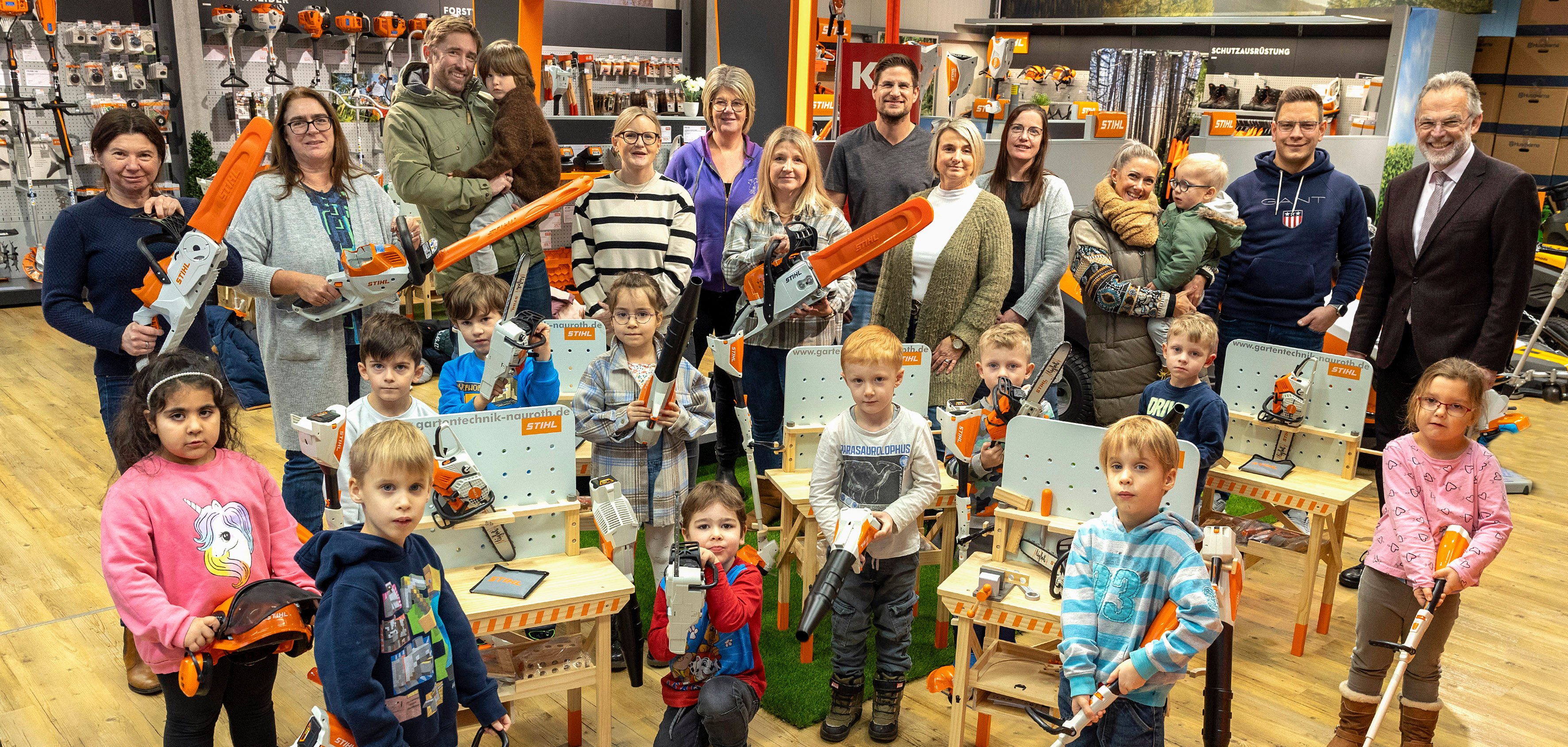 Personen bei der Übergabe und Kinder mit den neuen Spielzeugen