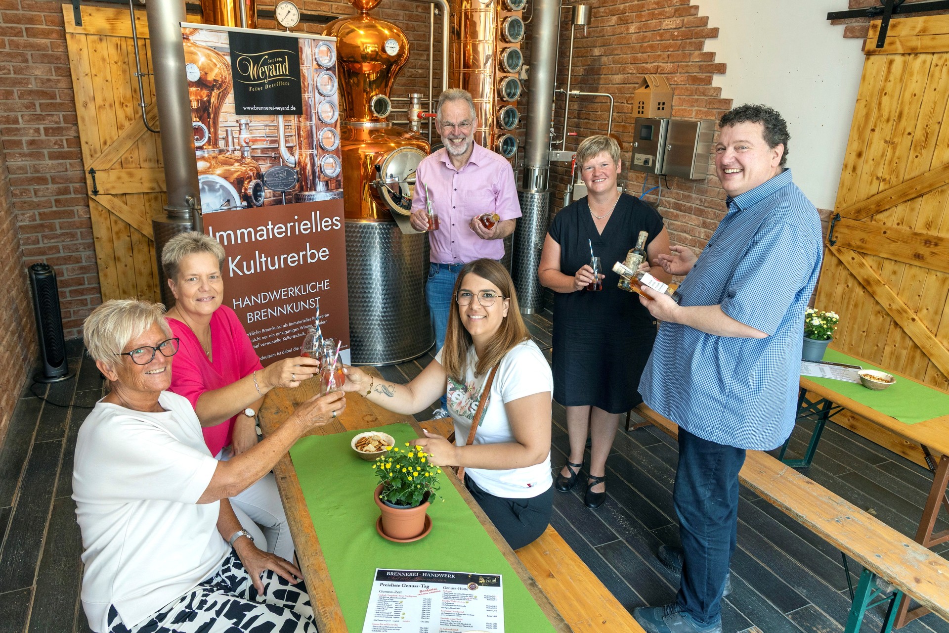 Inhaber Jochen Weyand (rechts) präsentierte anlässlich des Genusstages der Brennerei Weyand seine Erzeugnisse. Gemeinsam mit ihm freuten sich die Unnauer Ortsbürgermeisterin Iris Wagner und Bürgermeister Andreas Heidrich (2. und 3. v.r.) über die Aufnahme in die Liste „Immaterielles Kulturerbe“ der UNESCO
