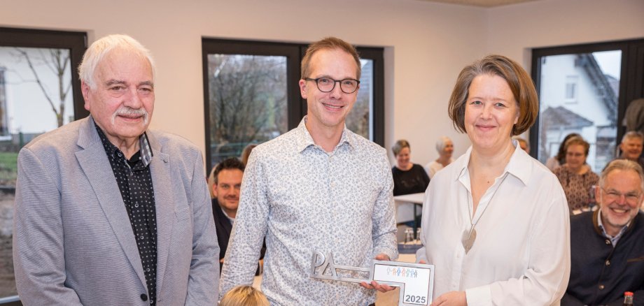 Philipp Alhäuser (Mitte) überreicht im Namen der beauftragten Architekten den symbolischen Schlüssel zum Anbau der Kindertagesstätte Langenbach an deren Leiterin Susanne Bronk (rechts) und Verbandsvorsteher Artur Schneider.