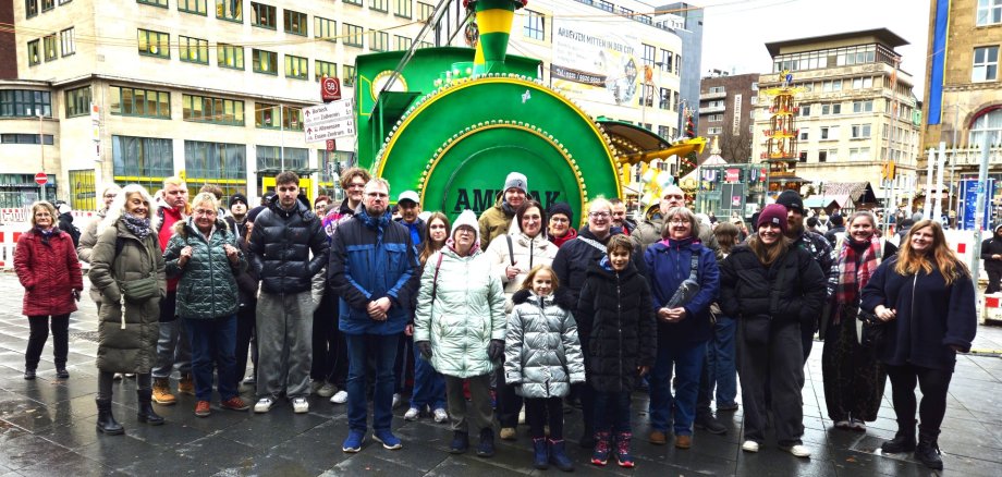 Jugendliche, Familien und Senioren hatten trotz grauem Regenwetter gleichermaßen Spaß beim ganztägigen gemeinsamen Entdecken der vielfältigen internationalen Angebote des Essener Weihnachtsmarktes und seiner besonderen Atmosphäre, hier vor einer Süßigkeiten-Lok am Eingang des Weihnachtsmarktes