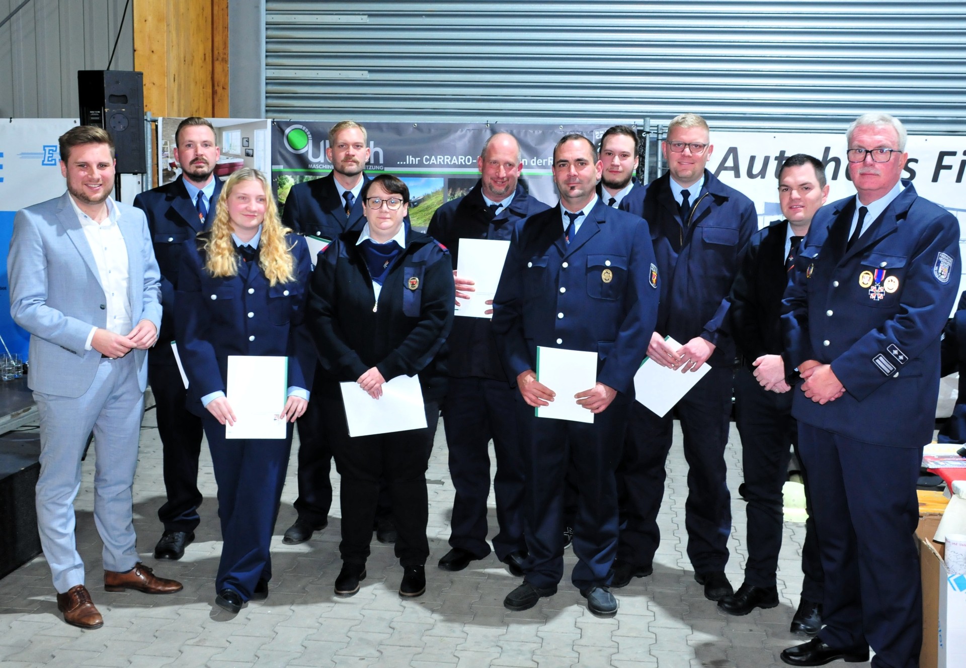 Gemeinsam mit Wehrleiter Frank Schiffmann und dessen Stellvertreter Tobias Schüler (v.r.) freute sich der Erste Beigeordnete Marvin Kraus (links) über das seltene 100-jährige Jubiläum der Freiwilligen Feuerwehr Hof. Im Rahmen der Veranstaltung nahm Kraus einige Ernennungen und Beförderungen der Hofer Wehrleute vor. Hintere Reihe: Pascal Schäfer (Oberfeuerwehrmann), Tim Robin Künkler (Oberfeuerwehrmann), der neu ernannte Wehrführer Christoph Renner sowie Theo Renner (Hauptfeuerwehrmann). Vordere Reihe: Clara Renner (Oberfeuerwehrfrau), Lena Weller (Verpflichtung), der frühere Wehrführer Dominic Jung und der neue stellvertretende Wehrführer Niclas Künkler.